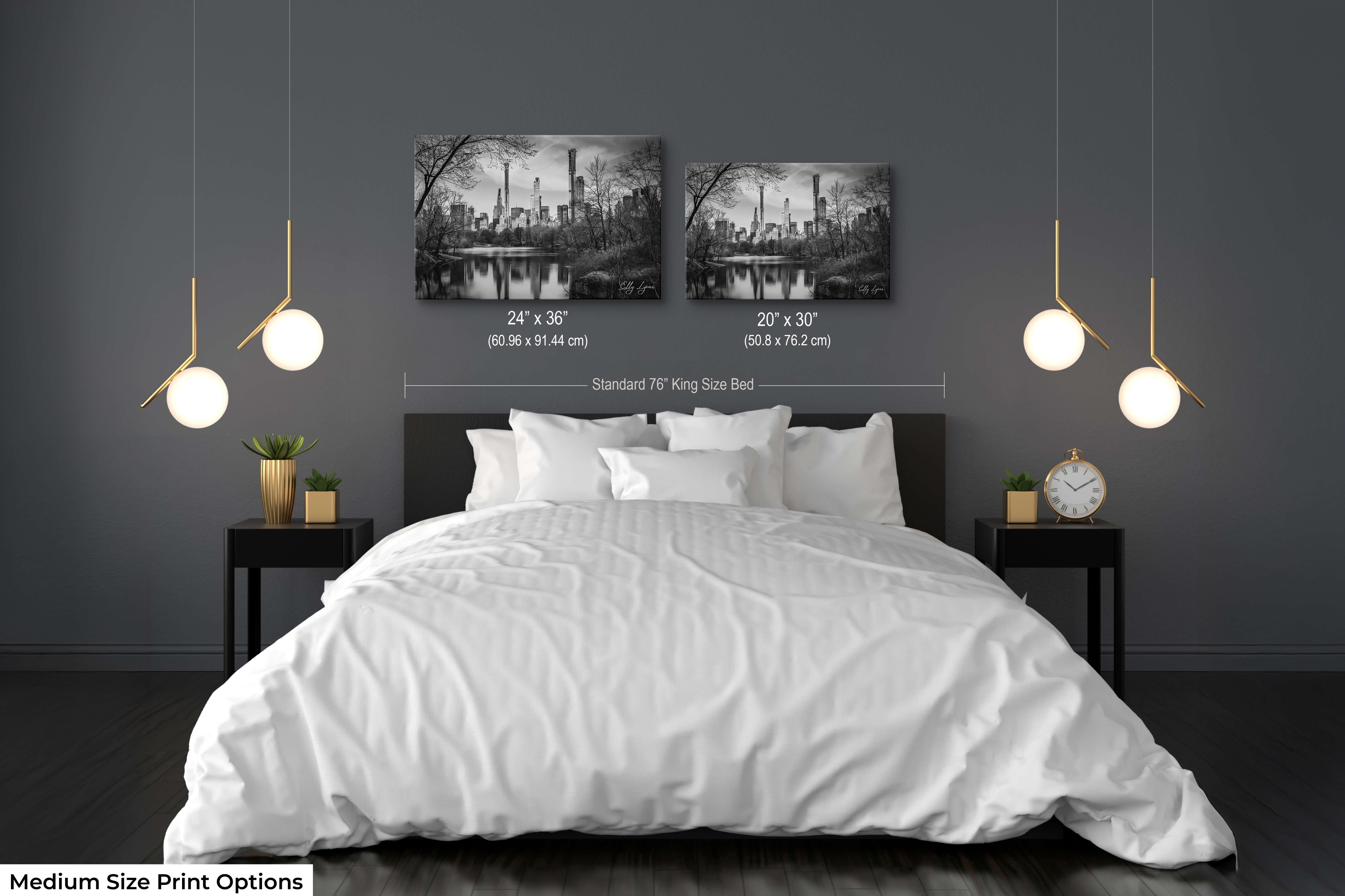 Set of two black and white cityscape prints hung above a bed in a minimalist bedroom.