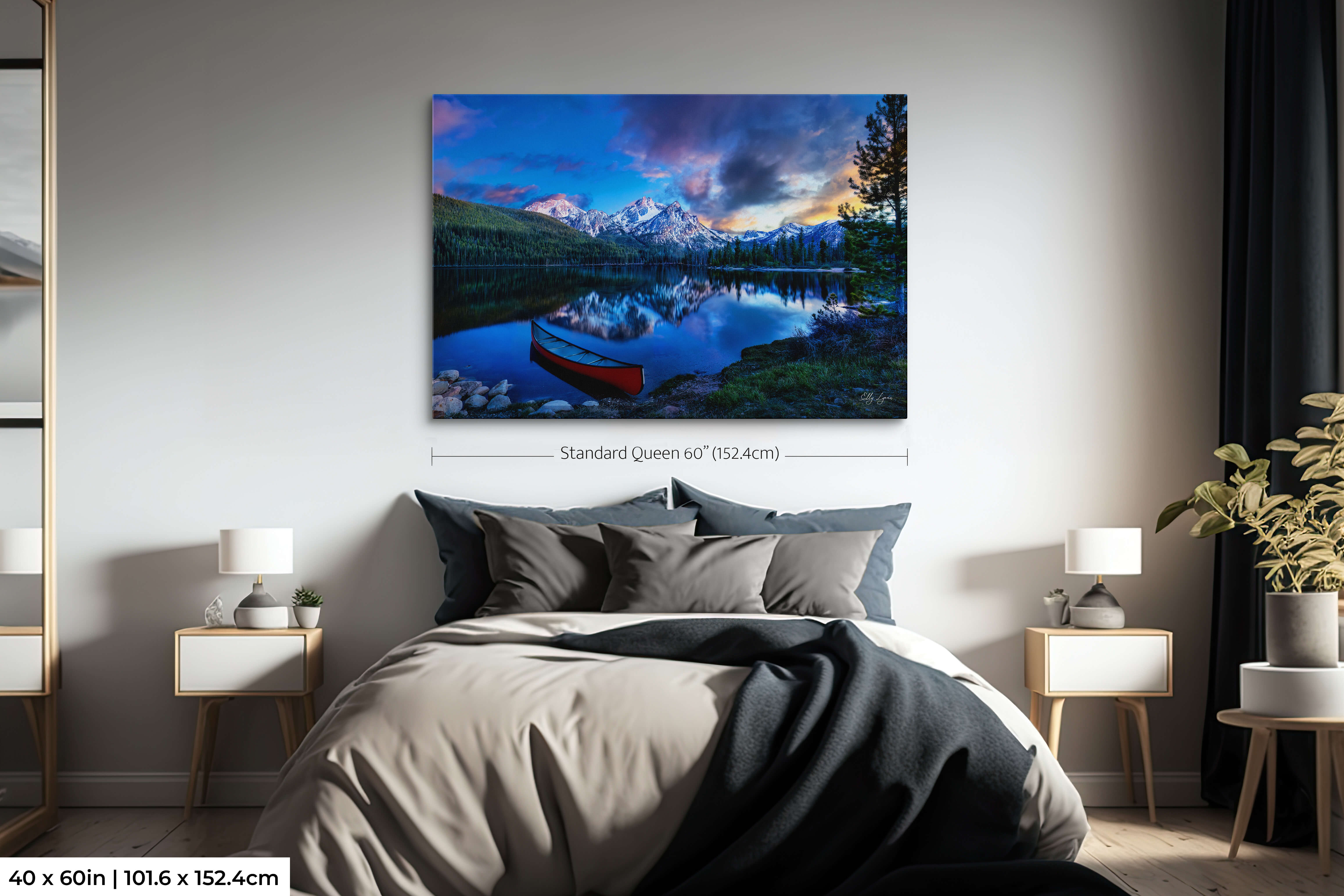 Statement wall art of snowy mountains and still lake at sunrise.