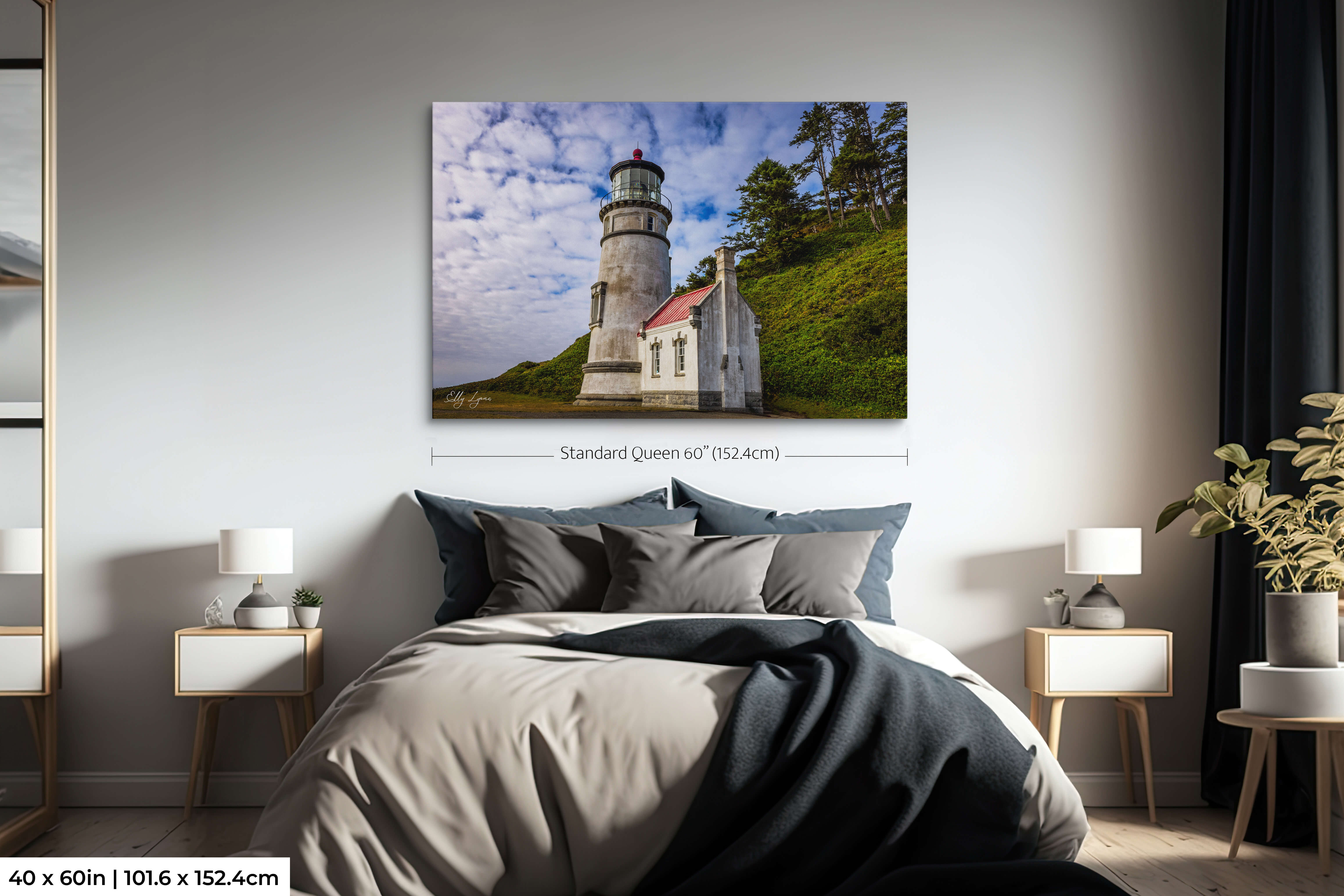 Oversized print of Heceta Head Lighthouse centered above bed in minimalist room.