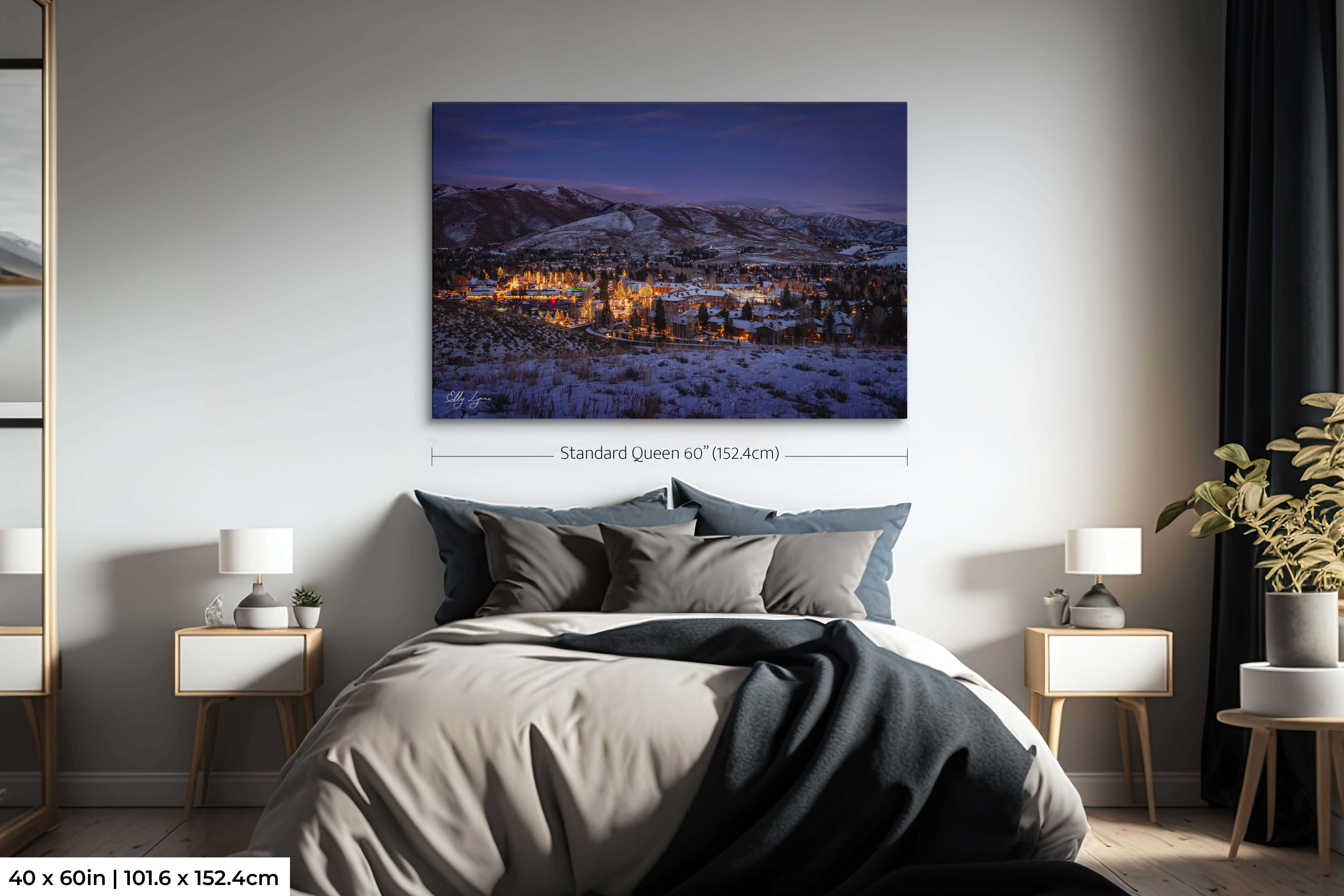Oversized print of a snowy town with Christmas lights under twilight sky.