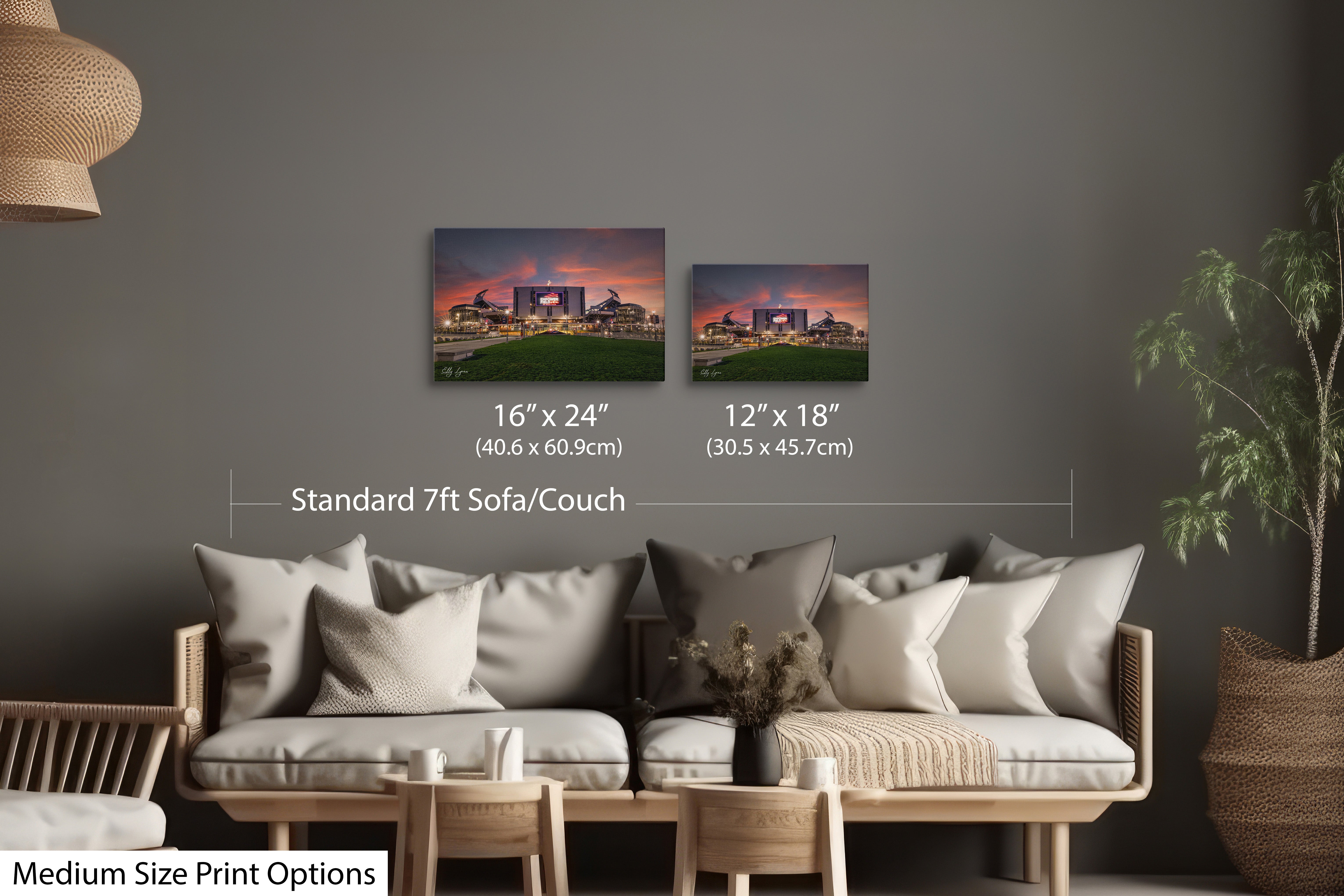 Empower Field at Mile High sunset wall art print displayed in 2 different print sizes of 12 by 18 inches and 16 by 24 inches styled over a standard couch/sofa showcasing size comparison and scale.